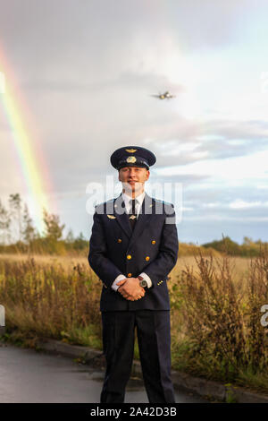Pilot steht auf Start- und Landebahn Regenbogen natur Landung Ebene hinter Stockfoto