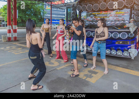 KANCHANABURI THAILAND - 1. SEPTEMBER: Nicht identifizierte weibliche Touristen tanzen vor den Bus am Parkplatz am September 1,2019 in Kanchanaburi, Thailand Stockfoto