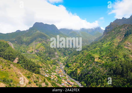 Atemberaubende Aussicht auf das malerische Dorf Serra de Aqua auf der Insel Madeira, Portugal. Kleine Stadt in einem Tal, das von grünen Bergen umgeben. Portugiesische Landschaft. Tolle Reiseziele. Stockfoto