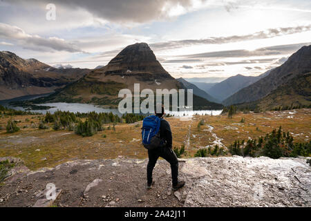 Ein junger Mann hoch und Blick auf die Landschaft von versteckten See bei Sonnenuntergang, Montana. Stockfoto