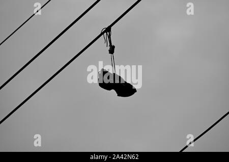 Alte Tennisschuh hängen von einer elektrischen Kabel Stockfoto