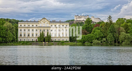 Großartige Aussicht auf die Festung Hohensalzburg, Schloss Leopoldskron und die Leopoldskroner Weiher in Salzburg bei den Sonnenuntergang, Österreich Stockfoto