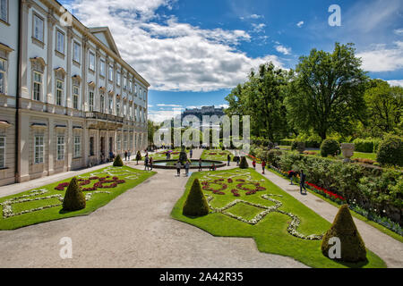 Salzburg, Österreich - 12. Mai 2017: Schloßpark Mirabell mit Touristen. Wunderbare Aussicht auf Schloßpark Mirabell mit der Festung Hohensalzburg im Hintergrund Stockfoto