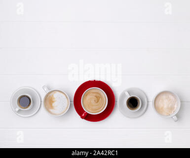 Verschiedene Kaffee in verschiedenen Bechern auf weißem Holz- Hintergrund Stockfoto