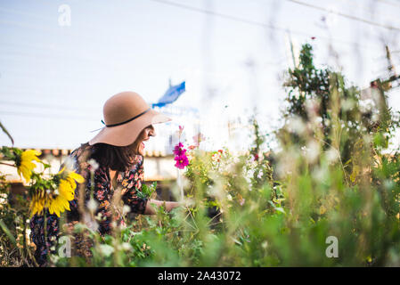 Glückliche Frau Blumen pflücken im Garten Stockfoto