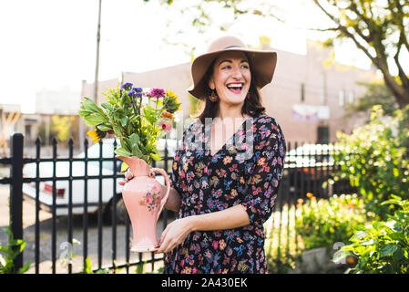 Glückliche Frau in einem städtischen Garten arbeiten Stockfoto