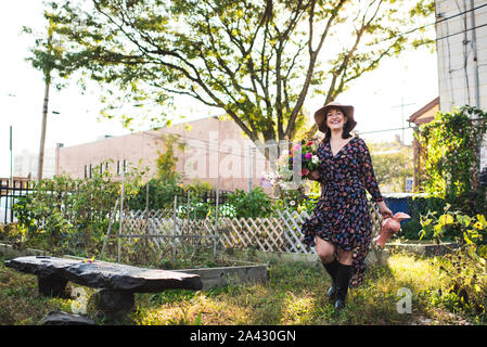 Glückliche Frau in einem städtischen Garten arbeiten Stockfoto