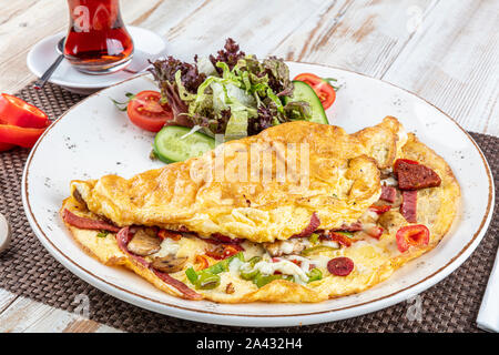 Gemischte Omelett; köstliche Omelette mit sucuk, Pilze gekocht und serviert mit gemischtem Gemüse für Folie Gerichte in weiße Platte für einen gesunden breakfa Stockfoto