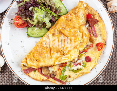 Gemischte Omelett; köstliche Omelette mit sucuk, Pilze gekocht und serviert mit gemischtem Gemüse für Folie Gerichte in weiße Platte für einen gesunden breakfa Stockfoto