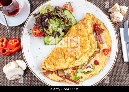 Gemischte Omelett; köstliche Omelette mit sucuk, Pilze gekocht und serviert mit gemischtem Gemüse für Folie Gerichte in weiße Platte für einen gesunden breakfa Stockfoto