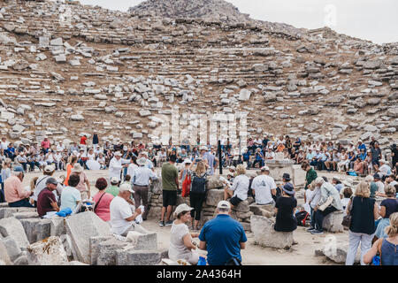 Delos, Griechenland - 20 September, 2019: Große Zahl der Touristen beobachten Leistung an das antike Theater auf der griechischen Insel Delos, ein archäologisches Stockfoto