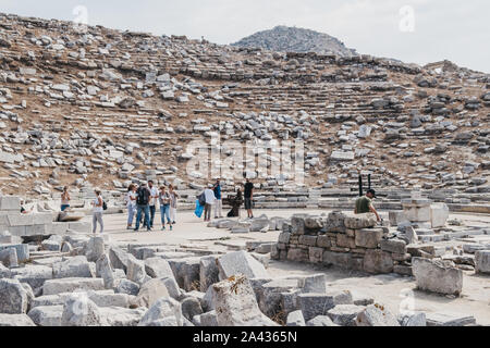 Delos, Griechenland - 20 September, 2019: Touristen zu Fuß unter den Ruinen des antiken Theater auf der griechischen Insel Delos, einer archäologischen Stätte in der Nähe von Mykonos Stockfoto