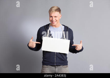 Fröhliche mann Pointing Finger auf leeres Namensschild. Stockfoto