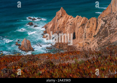 Praia do Ursa Strand mit schönen orangefarbene Klippen am Atlantik Küste in der Nähe von beliebten touristischen Cabo da Roca Leuchtturm, Portugal Stockfoto