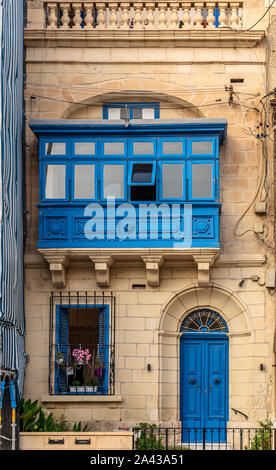 Wohnhaus Fassade mit blauer Tür, Fensterläden und traditionellen maltesischen Holz- geschlossenen Balkon in Sliema, Malta. Stockfoto