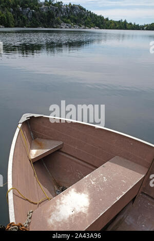 Alte rosa Beiboot/Ruderboot angedockt am Pier am See Stockfoto