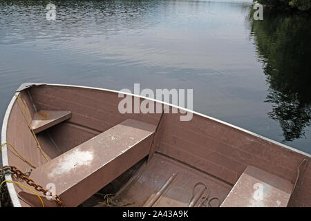 Alte rosa Beiboot/Ruderboot angedockt am Pier am See Stockfoto