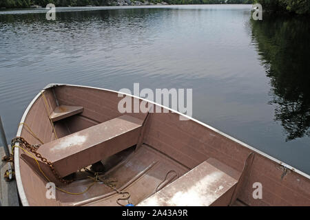 Alte rosa Beiboot/Ruderboot angedockt am Pier am See Stockfoto