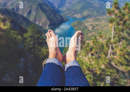 Man barfuß in Jeans gegen schöne Tal und die Hügel im Hintergrund. Gesunder Lebensstil und Natur Konzepte. Stockfoto