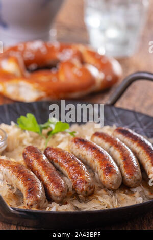 Gegrillten Nürnberger Bratwürste mit Sauerkraut Stockfoto