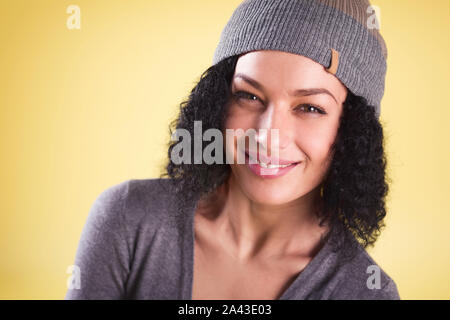 Nahaufnahme eines fröhlichen trendy Mädchen auf gelben Hintergrund. Stockfoto