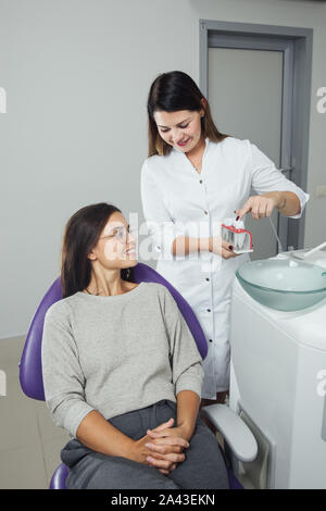 Eine Frau ist die Vorbereitung für eine zahnärztliche Untersuchung. Frau, die Zähne Zahnärzte untersucht. Stockfoto