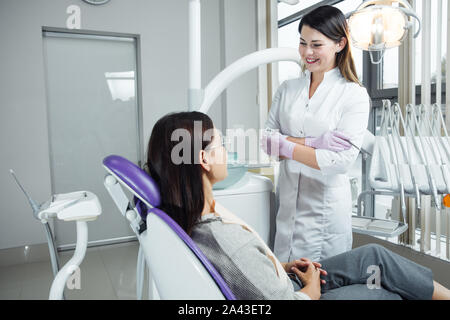 Eine Frau ist die Vorbereitung für eine zahnärztliche Untersuchung. Frau, die Zähne Zahnärzte untersucht. Stockfoto