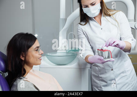 Eine Frau ist die Vorbereitung für eine zahnärztliche Untersuchung. Frau, die Zähne Zahnärzte untersucht. Stockfoto