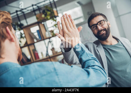 Männliche startupers zusammen arbeiten im Büro hoch fünf lächeln freundlich geben Stockfoto