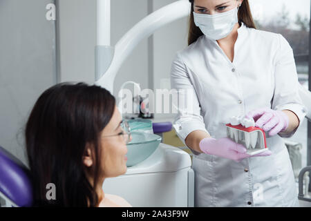 Eine Frau ist die Vorbereitung für eine zahnärztliche Untersuchung. Frau, die Zähne Zahnärzte untersucht. Stockfoto