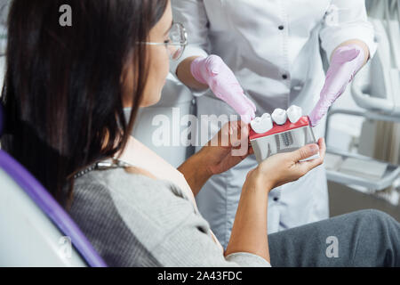 Eine Frau ist die Vorbereitung für eine zahnärztliche Untersuchung. Frau, die Zähne Zahnärzte untersucht. Stockfoto