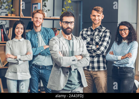 Startupers zusammen arbeiten im Büro stehen Chef close-up suchen Kamera zuversichtlich, während Mitarbeiter lächeln Stockfoto