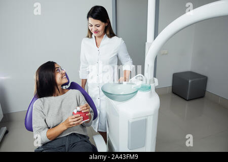 Eine Frau ist die Vorbereitung für eine zahnärztliche Untersuchung. Frau, die Zähne Zahnärzte untersucht. Stockfoto