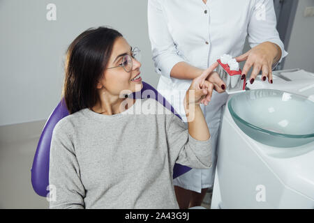 Eine Frau ist die Vorbereitung für eine zahnärztliche Untersuchung. Frau, die Zähne Zahnärzte untersucht. Stockfoto