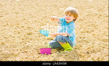 Glückliches Kind Gärtner Gärtnerei. Frühling Saison. Tag der Erde. neues Leben. Sommer Bauernhof. kleines Kind Einpflanzen einer Blume. Mensch und Natur. Organic Farm. planet Schutz. Die Arbeit mit Vergnügen. Stockfoto