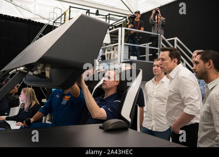 Hawthorne, Vereinigten Staaten von Amerika. 10. Oktober, 2019. NASA-Administrator Jim Bridenstine, Mitte, nimmt an einem crew Dragon Flight Simulation während SpaceX Gründer und CEO Elon Musk, rechts, während einer Tour der SpaceX Hauptsitz Oktober 10, 2019 in Hawthorne, Kalifornien aussieht. Credit: Aubrey Gemignani/NASA/Alamy leben Nachrichten Stockfoto