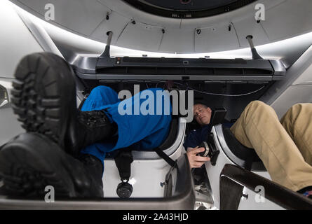 Hawthorne, Vereinigten Staaten von Amerika. 10. Oktober, 2019. NASA-Administrator Jim Bridenstine, rechts, sitzt in einem MOCKUP der Demo-2 Crew Dragon mit NASA-Astronaut Bob Behnken während einer Tour der SpaceX Hauptsitz Oktober 10, 2019 in Hawthorne, Kalifornien. Credit: Aubrey Gemignani/NASA/Alamy leben Nachrichten Stockfoto