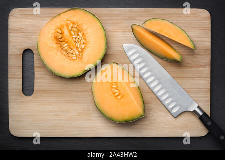 Schneiden Zucker Melone auf einem Schneidebrett. Stockfoto