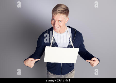 Glücklich der Mensch, der Finger am weißen leeren Namensschild. Stockfoto