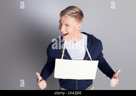 Freudiger mann Daumen hoch, der leeres Namensschild. Stockfoto