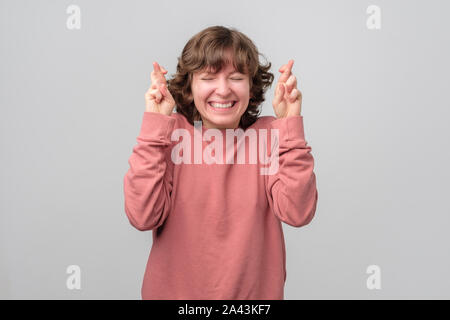 Frau mit Blick begeistert und halten die Daumen und hoffen für gutes Glück Stockfoto