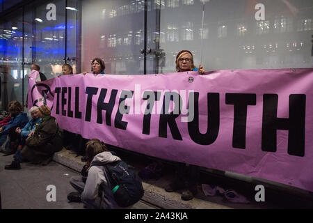 London, Großbritannien. 11. Oktober, 2019. Klima Aktivisten vor dem Aussterben Rebellion Block der Haupteingang des neuen BBC Broadcasting House am Abend des fünften Tages der Internationalen Rebellion Proteste. Sie forderten, dass der Fernsehveranstalter "Sag die Wahrheit" in Bezug auf die Klima Notfall. Credit: Mark Kerrison/Alamy leben Nachrichten Stockfoto