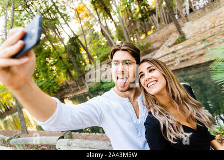 Zwei schöne und gesunde junge Menschen nehmen eine selfie Foto mit Ihrem neuen Smartphone zwischen Witze. Stockfoto