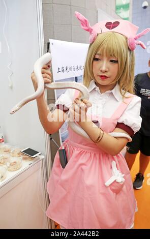 Ein cosplayer hält eine weiße Schlange bei Pet Fair Asia 2019 in Shanghai, China, 23. August 2019. *** Local Caption *** fachaoshi Stockfoto