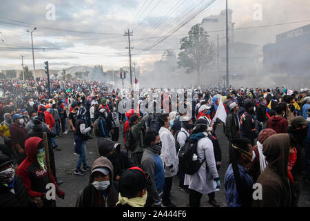 Quito, Ecuador. 11 Okt, 2019. Die Teilnehmer an einer Demonstration stand in einer Wolke von Tränengas. Am Freitag, gab es schwere Auseinandersetzungen mit der Polizei in neue Protestaktionen gegen die Erhöhung der Treibstoffpreise in Ecuador. Credit: Sara Bandes/dpa/Alamy leben Nachrichten Stockfoto