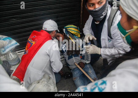 Quito, Ecuador. 11 Okt, 2019. Die Demonstranten sind fürsorglich für einen verletzten Mann. Am Freitag, gab es schwere Auseinandersetzungen mit der Polizei in neue Protestaktionen gegen die Erhöhung der Treibstoffpreise in Ecuador. Credit: Sara Bandes/dpa/Alamy leben Nachrichten Stockfoto