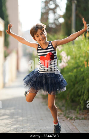 Kleines Mädchen, acht Jahre alt, springen im Freien. Stockfoto