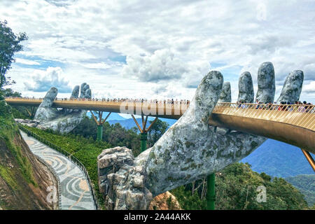 Touristen besuchen die Goldene Brücke von Hand gehalten, Statuen von Nebel und Wolken auf dem Bana Hügeln in Da Nang, Vietnam, 19. August 2019 umgeben. Bana H Stockfoto