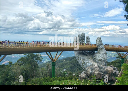 Touristen besuchen die Goldene Brücke von Hand gehalten, Statuen von Nebel und Wolken auf dem Bana Hügeln in Da Nang, Vietnam, 19. August 2019 umgeben. Bana H Stockfoto