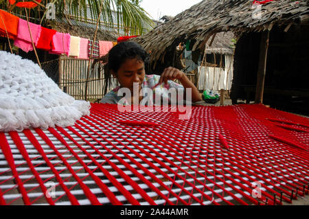 Ein Mädchen aus der ethnischen Rakhain community Weberei Tuch mit einem traditionellen Handwebstühlen. Kuakata, Patuakhali, Bangladesch. Stockfoto